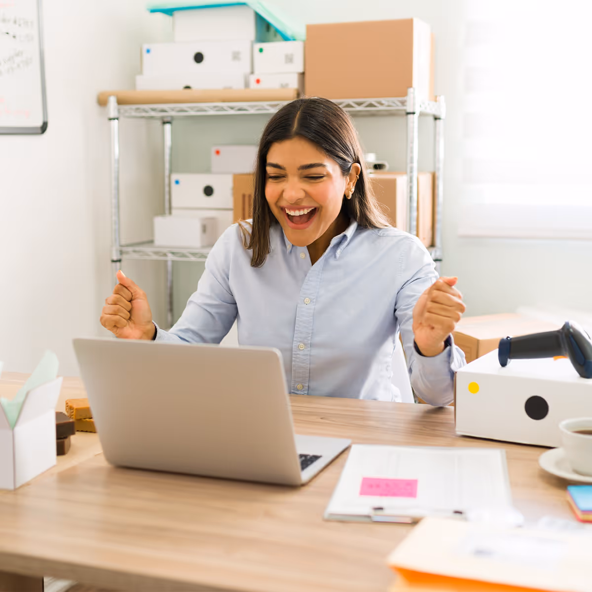 Merchant reacting happily while reviewing Shopify activity on a laptop